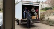 Junk Throw junk removal team loading heavy furniture into a service truck during a residential cleanout in Portland, OR.